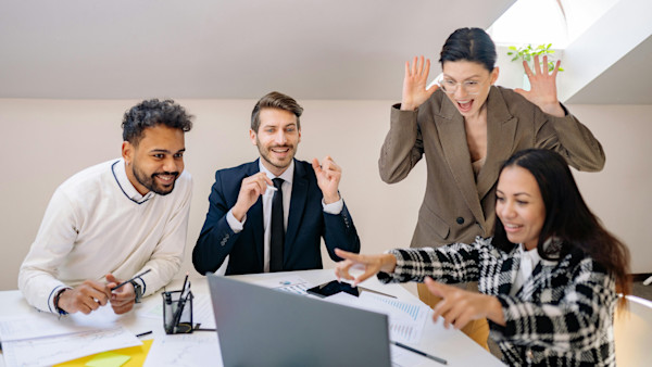 A Group of Happy People Looking at a Laptop
