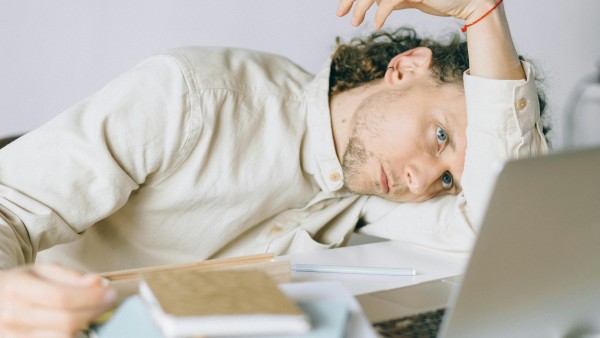 Overworked employee lying in front of a laptop