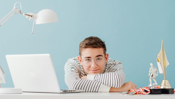 A man resting his chin on his arm on a desk