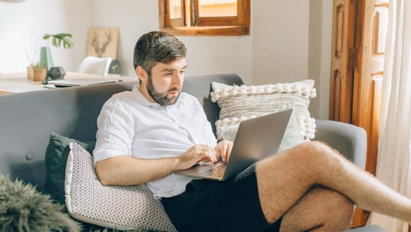 Man sitting on a sofa and using a laptop