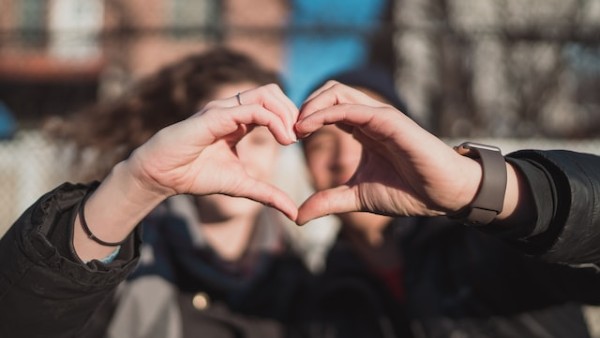 two person combine hand forming a heart hand gesture