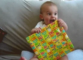 A baby very excited about a birthday present