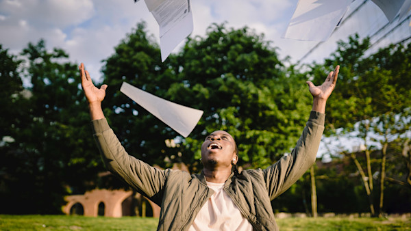 Happy student throwing papers in the air