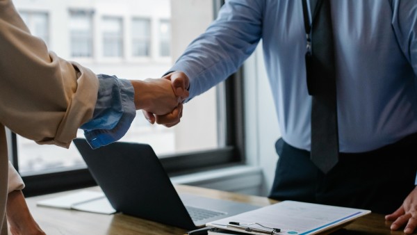 Colleagues shaking hands in office