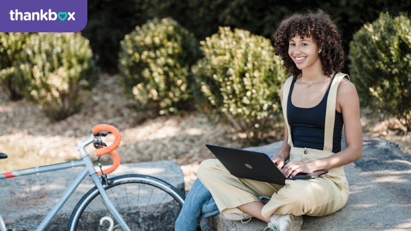 Cheerful female using laptop outdoors