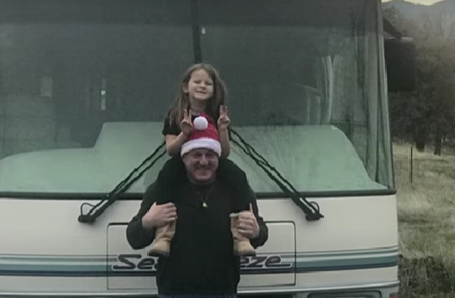 Luna and her Dad in Santa hat with one of the emergency RVs to help the homeless from Californian wildfires