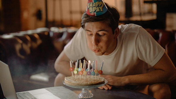 Man blowing candles on a birthday cake