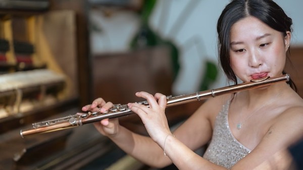 Skilled Asian musician playing flute
