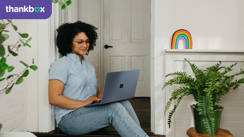 A woman sitting on the floor and using a laptop