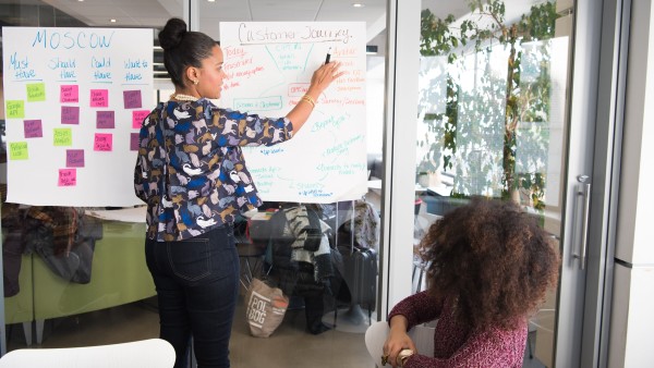 Two businesswomen having a meeting inside a glass-panel office