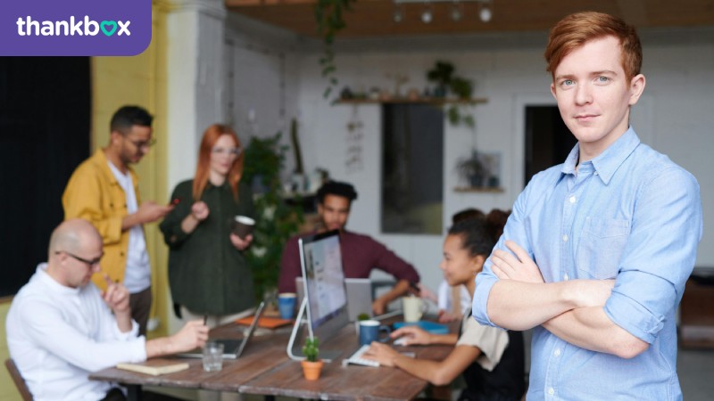 Man standing beside his team in the office