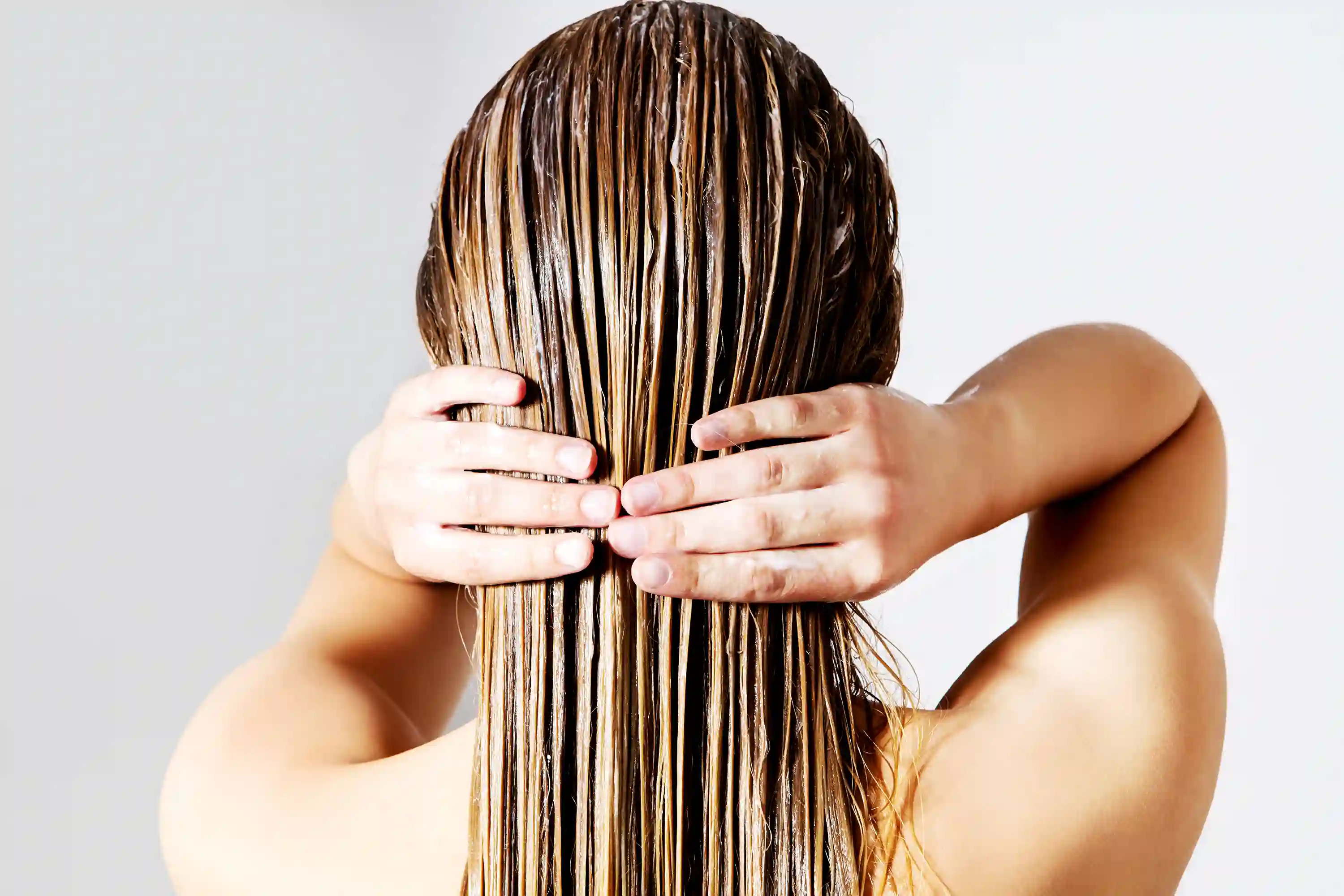 Woman shampooing hair to protect and prolong color-treated hair