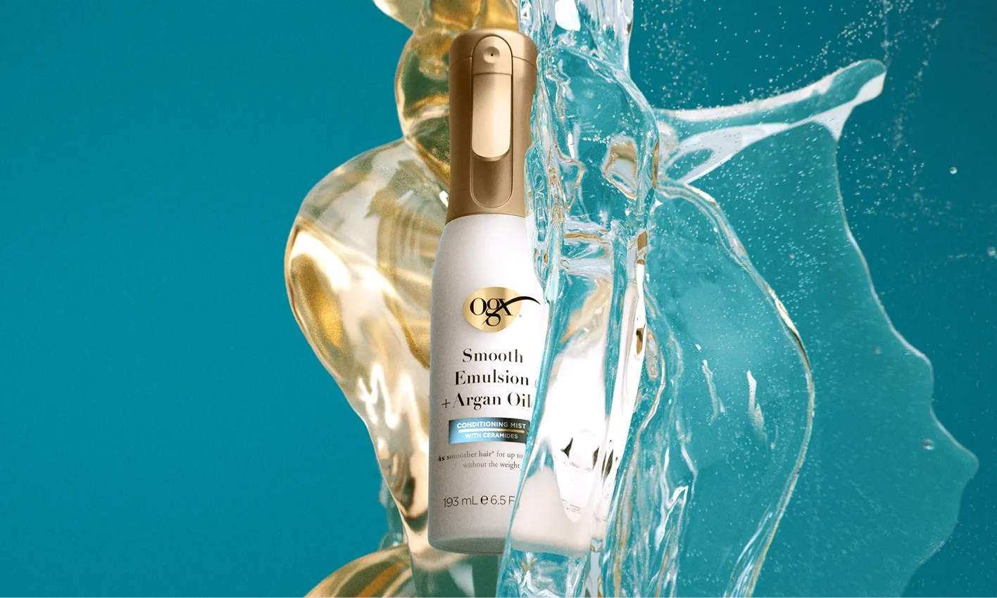 Bottle of Smooth Emulsion + Argan Oil Conditioning Mist being splashed and covered in oil