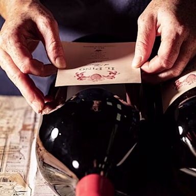 Mitarbeiter der Tenuta di Biserno klebt die Etikette bei einem «Il Pino» auf