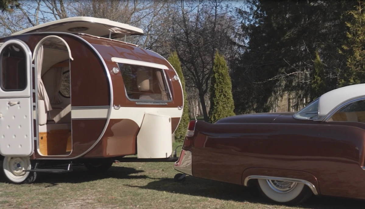 Michaels Cadillac Coupé DeVille, 5,4 er fra 1955 og har kørt 1.200 kilometer. Den har to døre. Campingvognen er fra 1965.