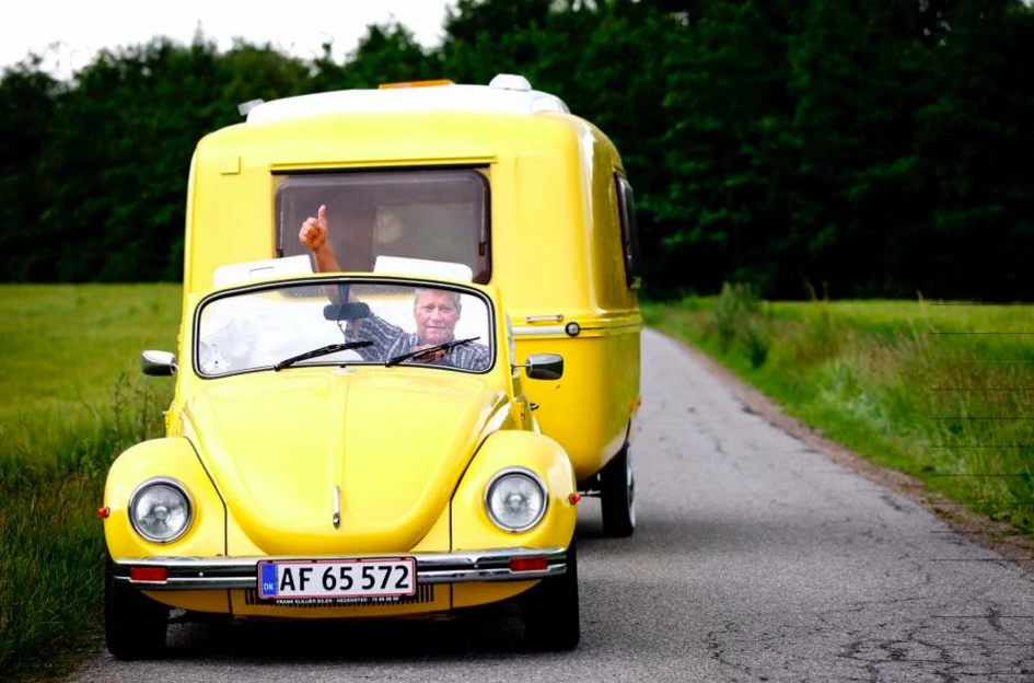 Johnnys solgule VW Cabriolet fra 1971 med matchende campingvogn giver tommeltotter på landevejen, fortæller han