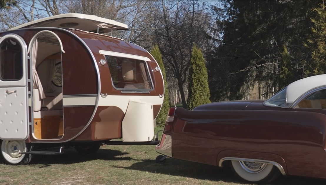 Michaels Cadillac Coupé DeVille, 5,4 er fra 1955 og har kørt 1.200 kilometer. Den har to døre. Campingvognen er fra 1965.