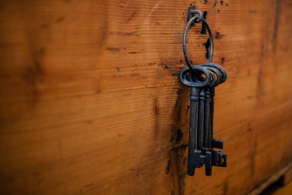 A photo of black skeleton keys on a wooden background