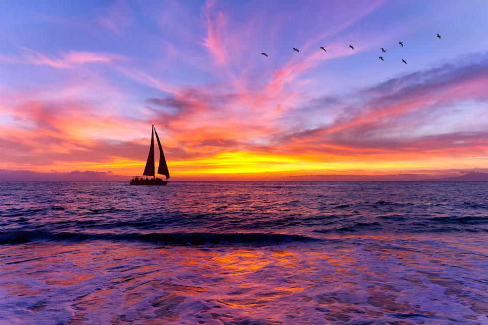 A sailboat sailing against a sunset