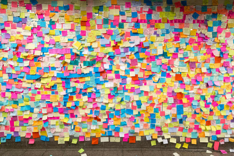 A photo of a wall covered in sticky notes.