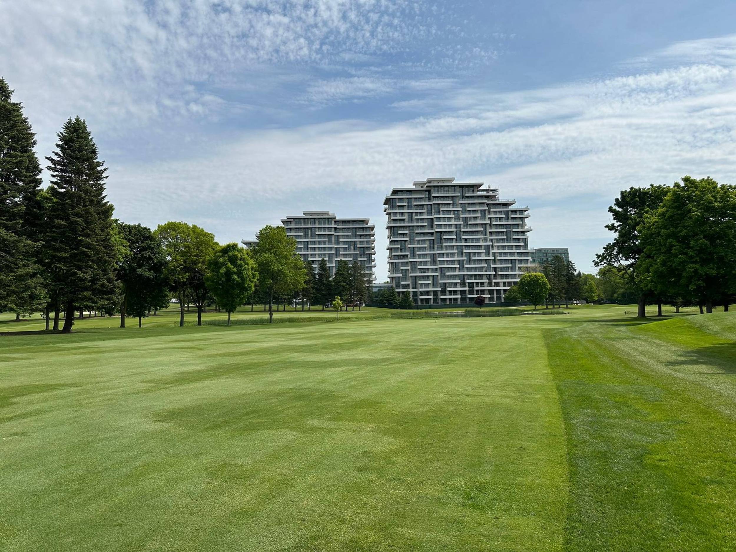 A clear distance view of green golf course grass leading up to Royal Bayview, while on the Ladies' Golf Club of Toronto course.
