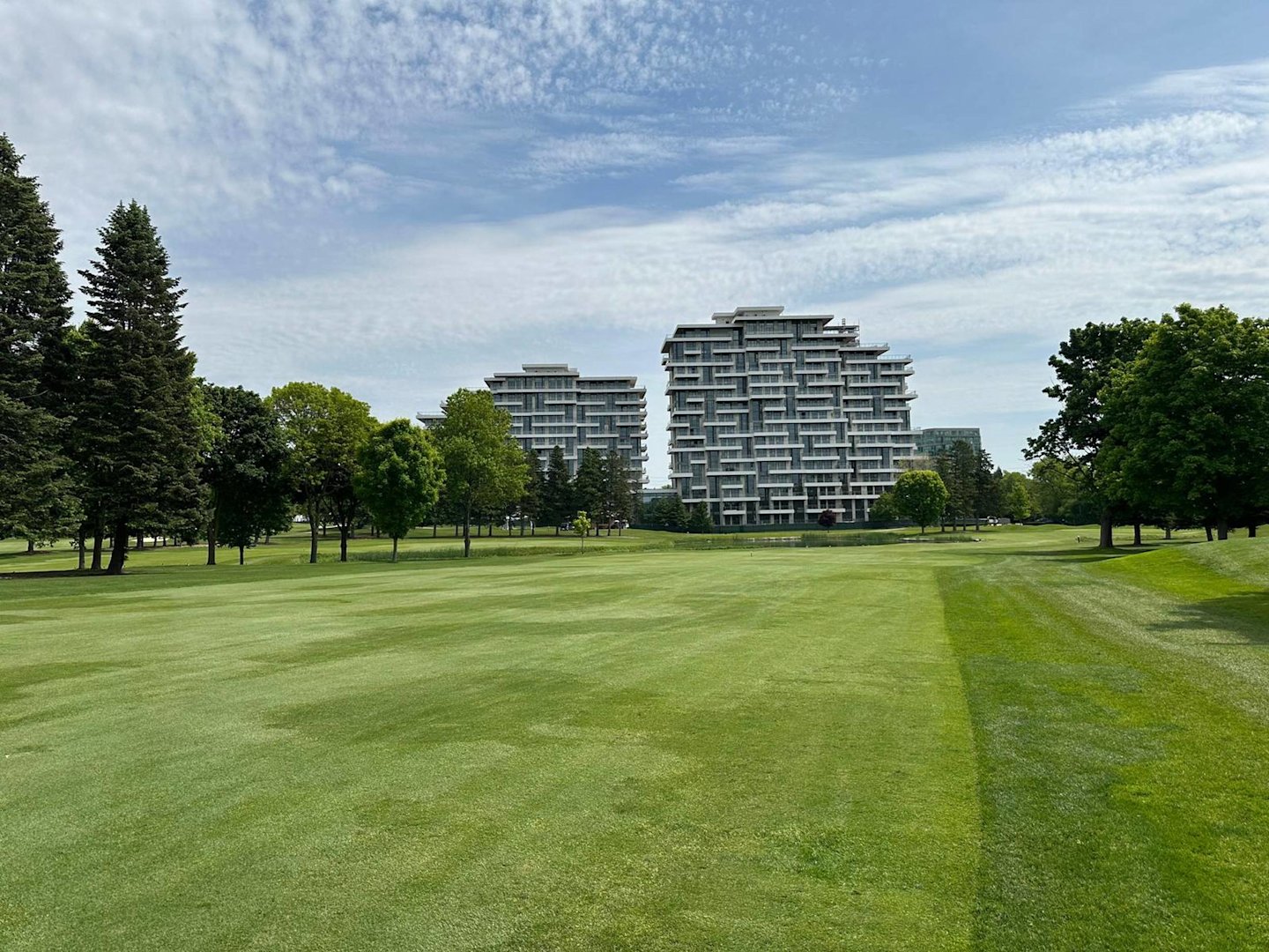 A clear distance view of green golf course grass leading up to Royal Bayview, while on the Ladies' Golf Club of Toronto course.