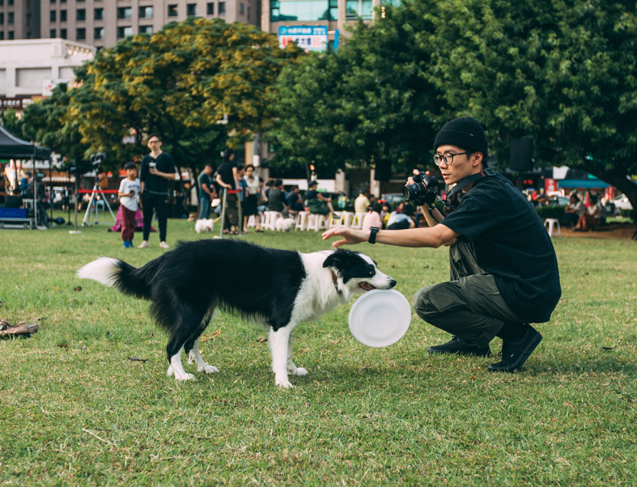 A man playing with his dog in a dog park close to The Well