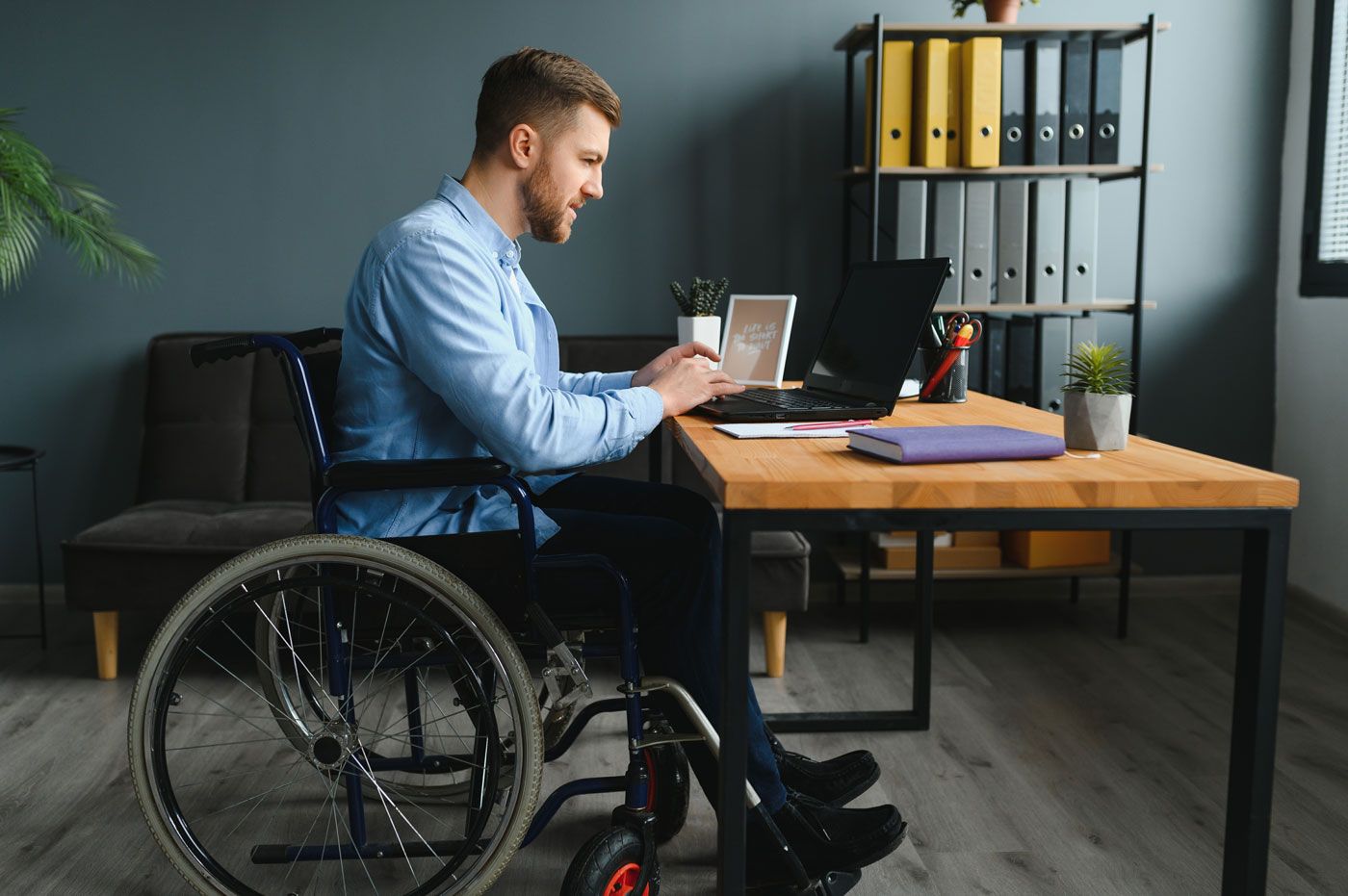 Man in wheelchair working at a desk