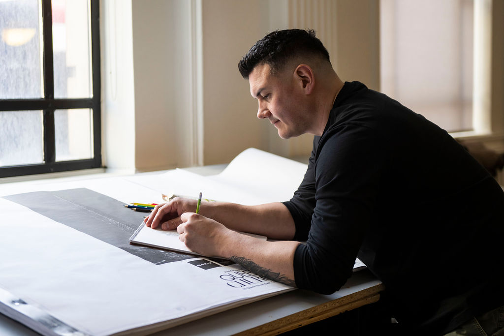 Indigenous artist Patrick Hunter sketching artwork