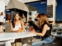 Two women sitting at a brewery patio