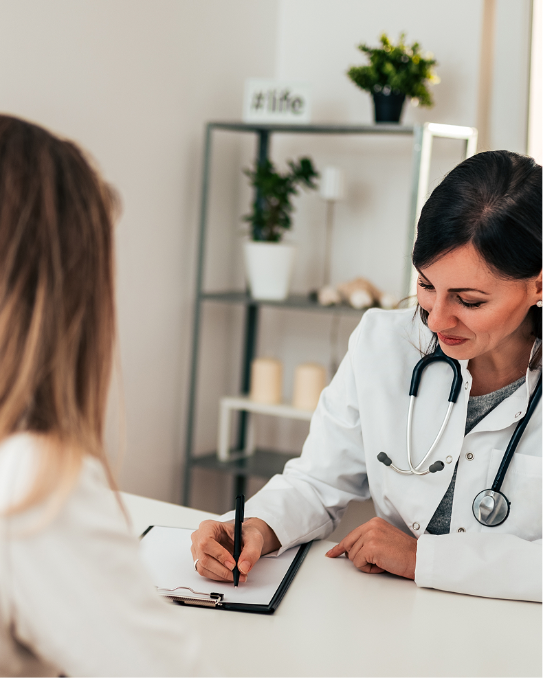 Provider taking notes during a visit with a patient