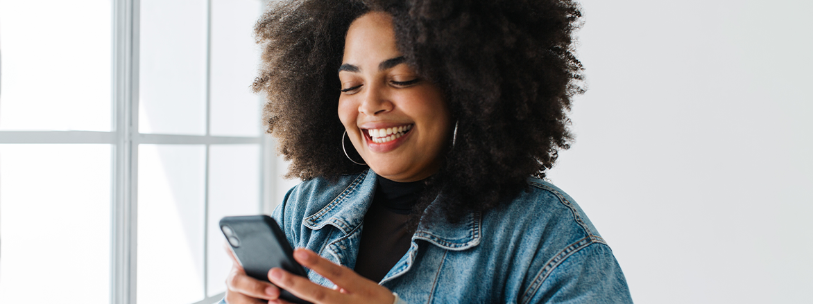 smiling young woman using phone for women’s health virtual visit