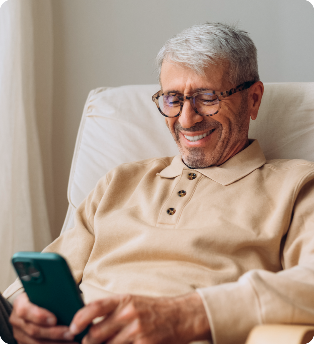 Senior man smiling at smartphone