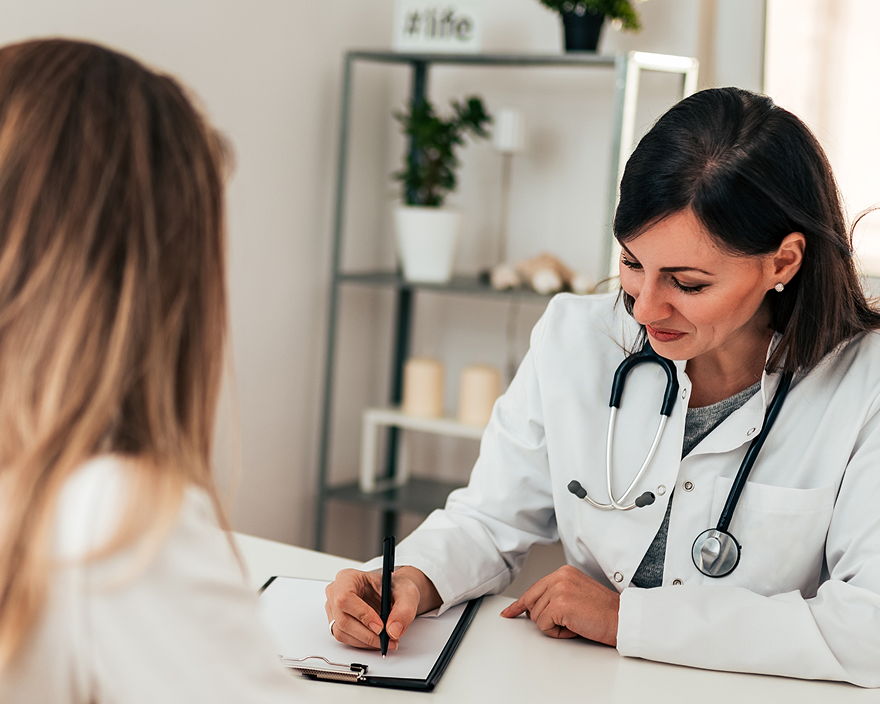 Provider taking notes during a visit with a patient