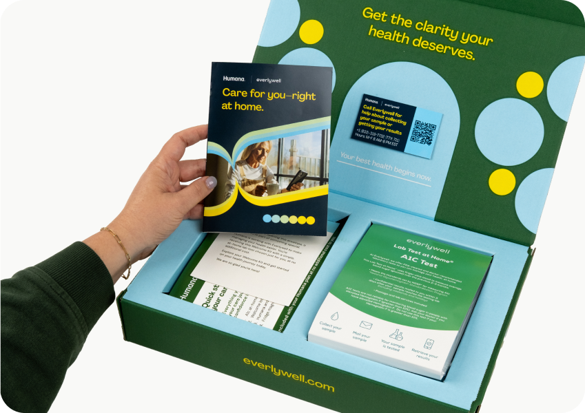 Hand holding A1c kit instructions about to collect sample