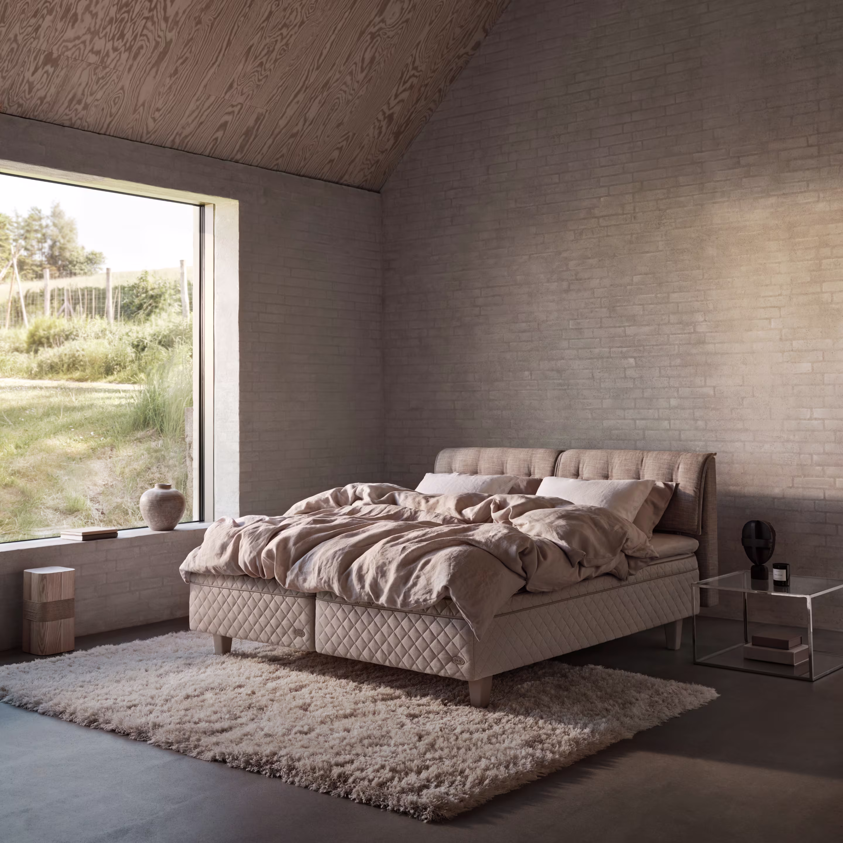 Sovrum med en bäddad DUX-säng i beige toner, placerad på en ljus matta intill ett stort fönster med utsikt över en grön trädgård.