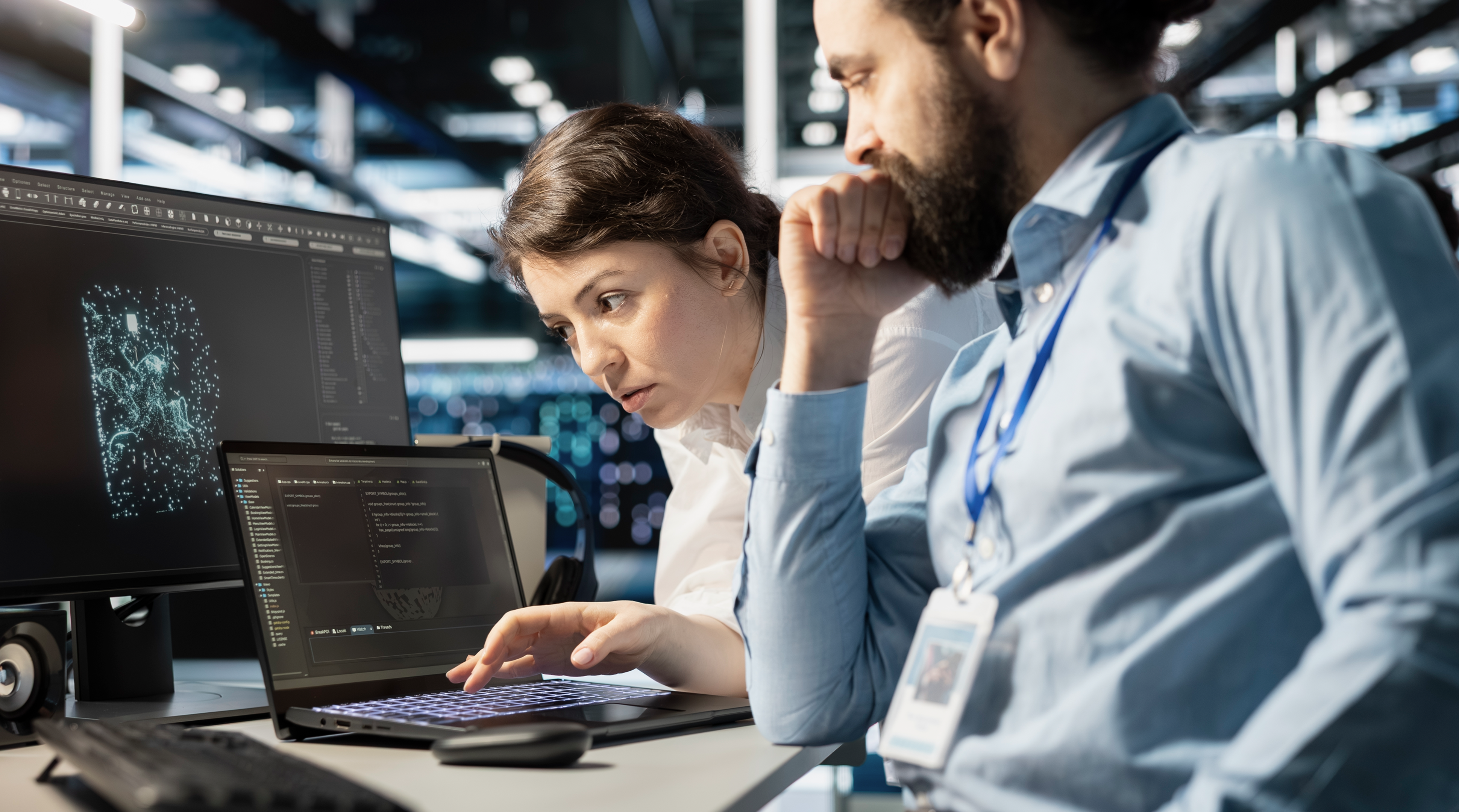 Team of programmers using notebook in server room, analyzing data. Data center office IT experts doing brainstorming, examining code on laptop, ensuring system integrity and security