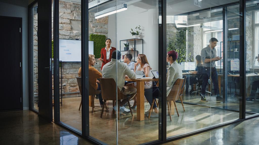 Group of people in glass office at a meeting