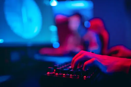 Red hands typing on keyboard