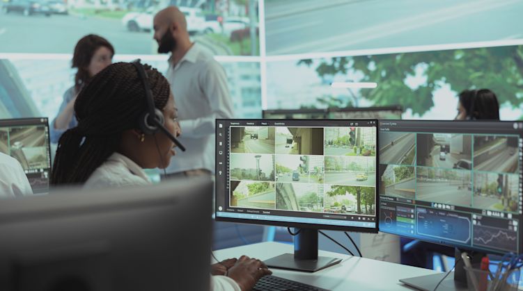 Man dispatch operator uses satellite sensors system to ensure public safety on city streets, monitoring traffic via CCTV security cameras at stop lights