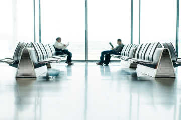 Two men sitting at the airport