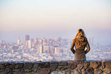 A woman looking into a distance - Easy ways to save money on travel