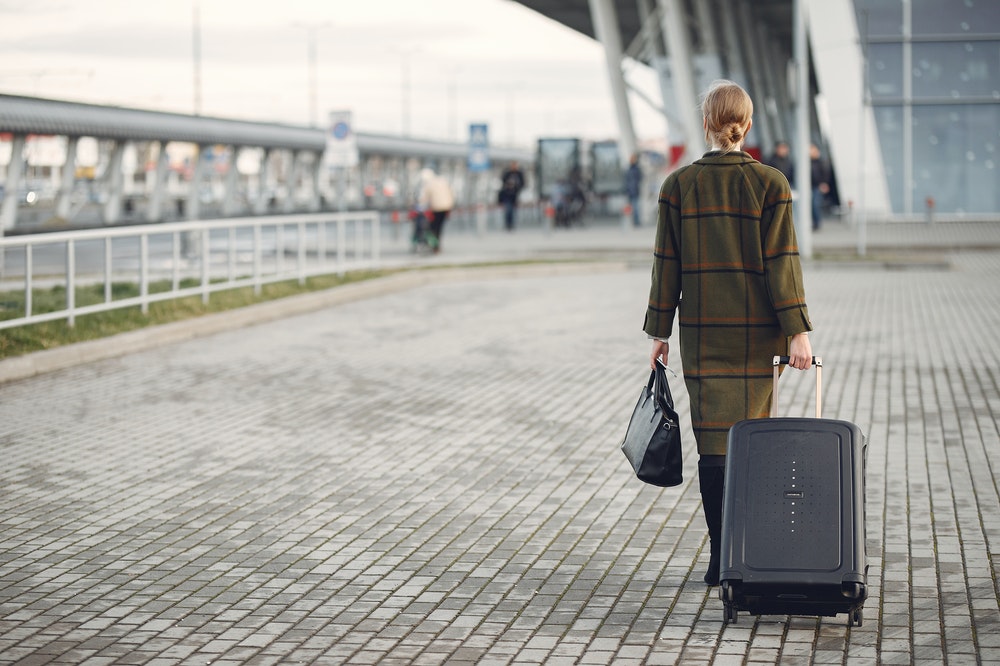 Woman with a suitcase walking to the airport