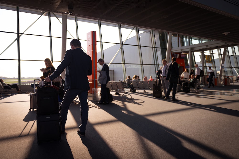 A man with a suitcase at an airport gate