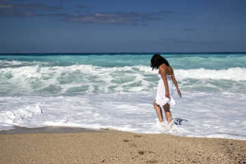 Woman wearing a white dress on the beach