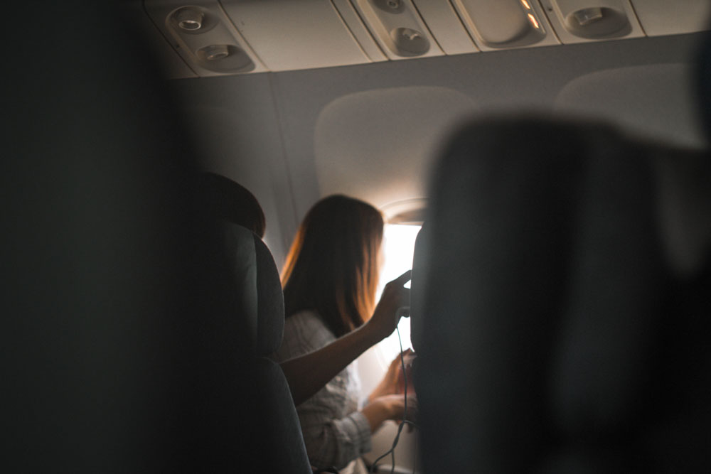 Woman sitting by the window of an airplane