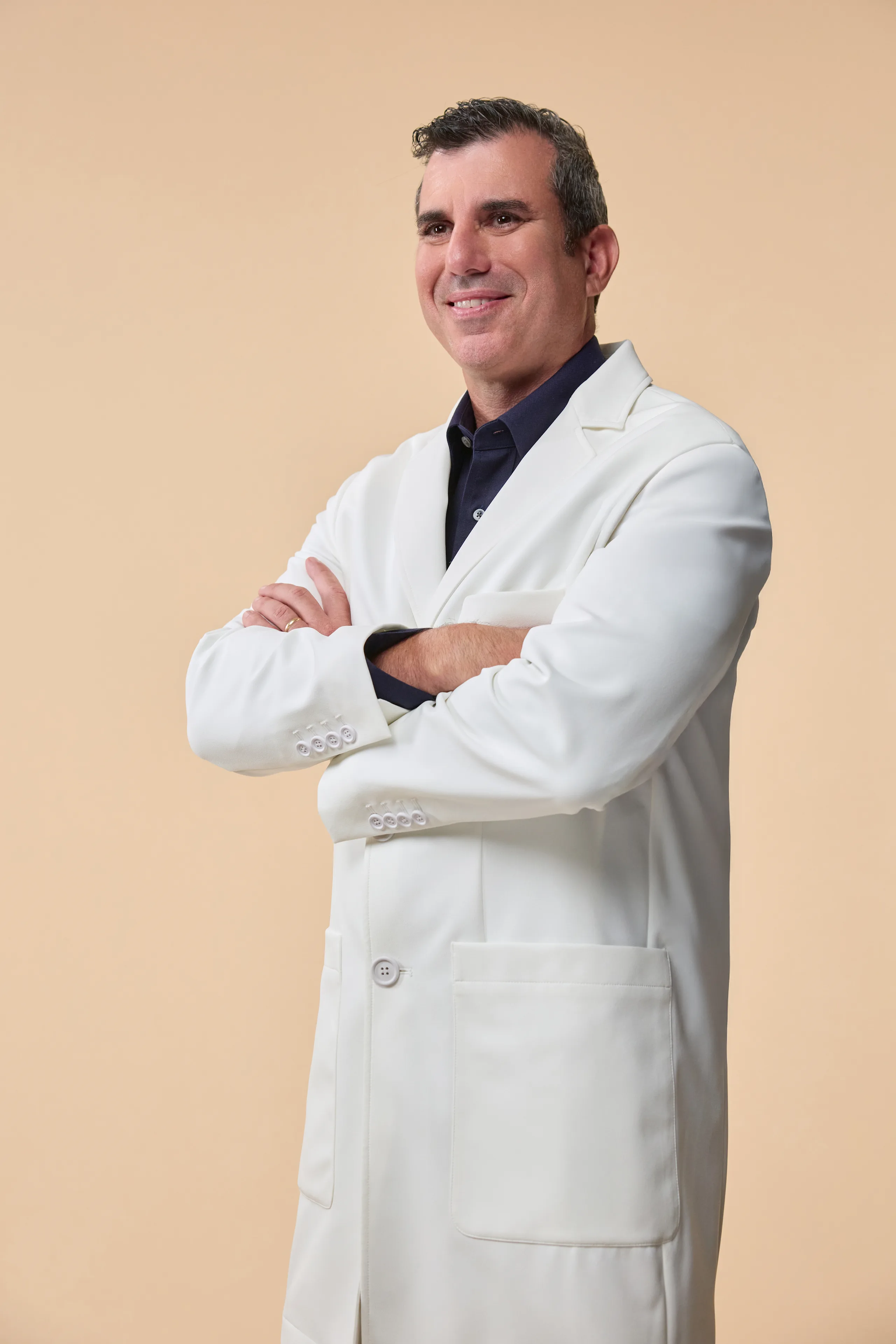 Doctor with crossed arms looks happily to side of camera
