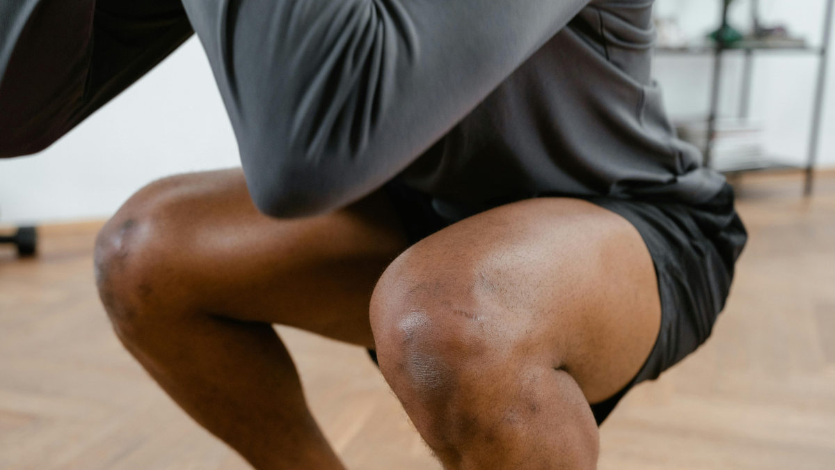 Man performing a deep bodyweight squat, a functional exercise that trains the core