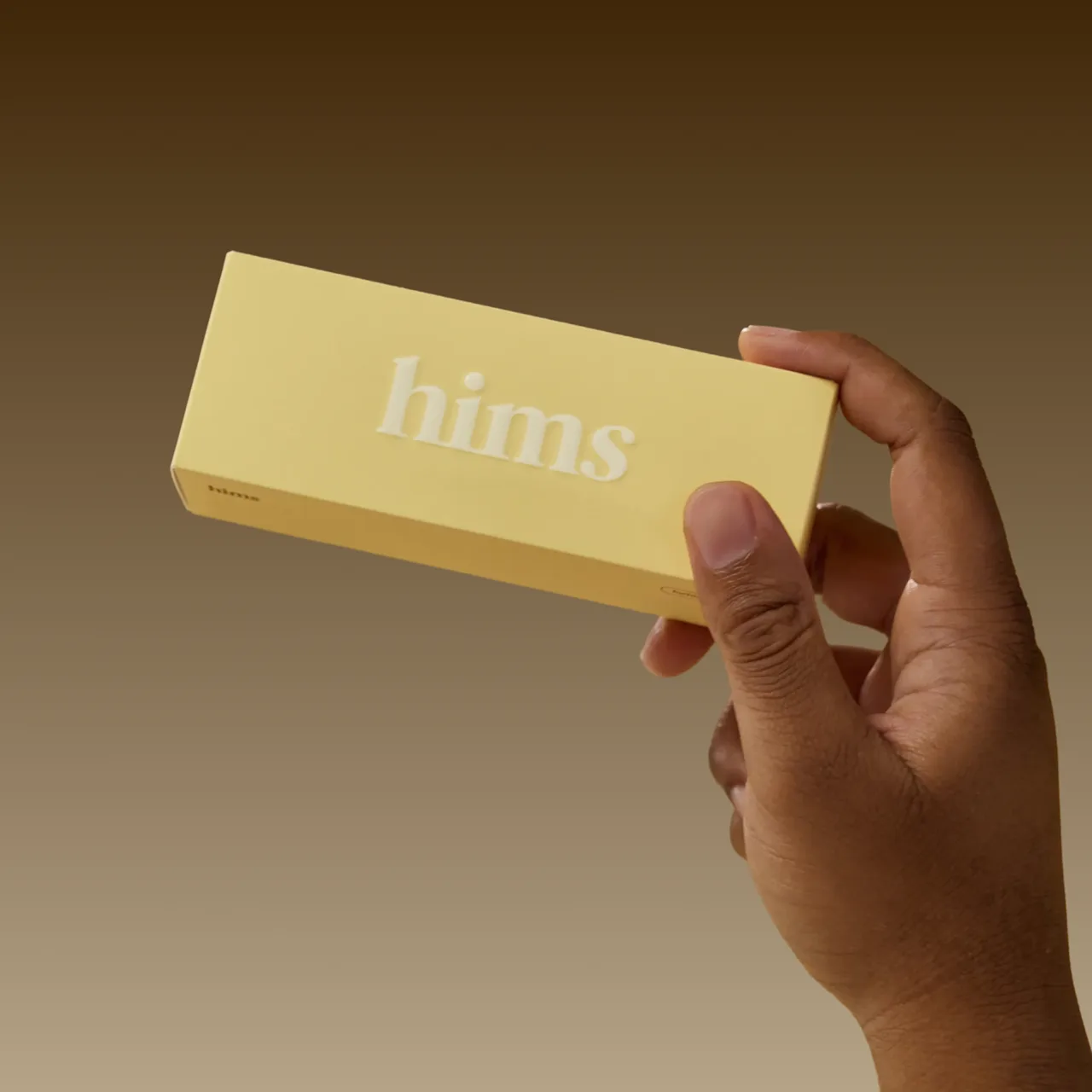 Person holding the hims product yellow box
