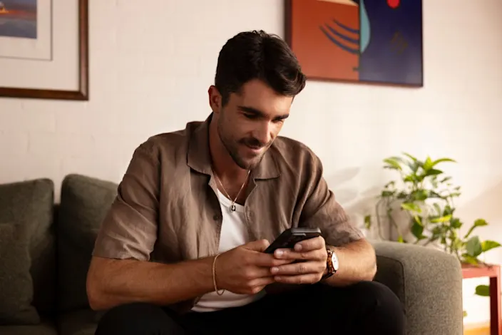A person sitting in a couch using his phone